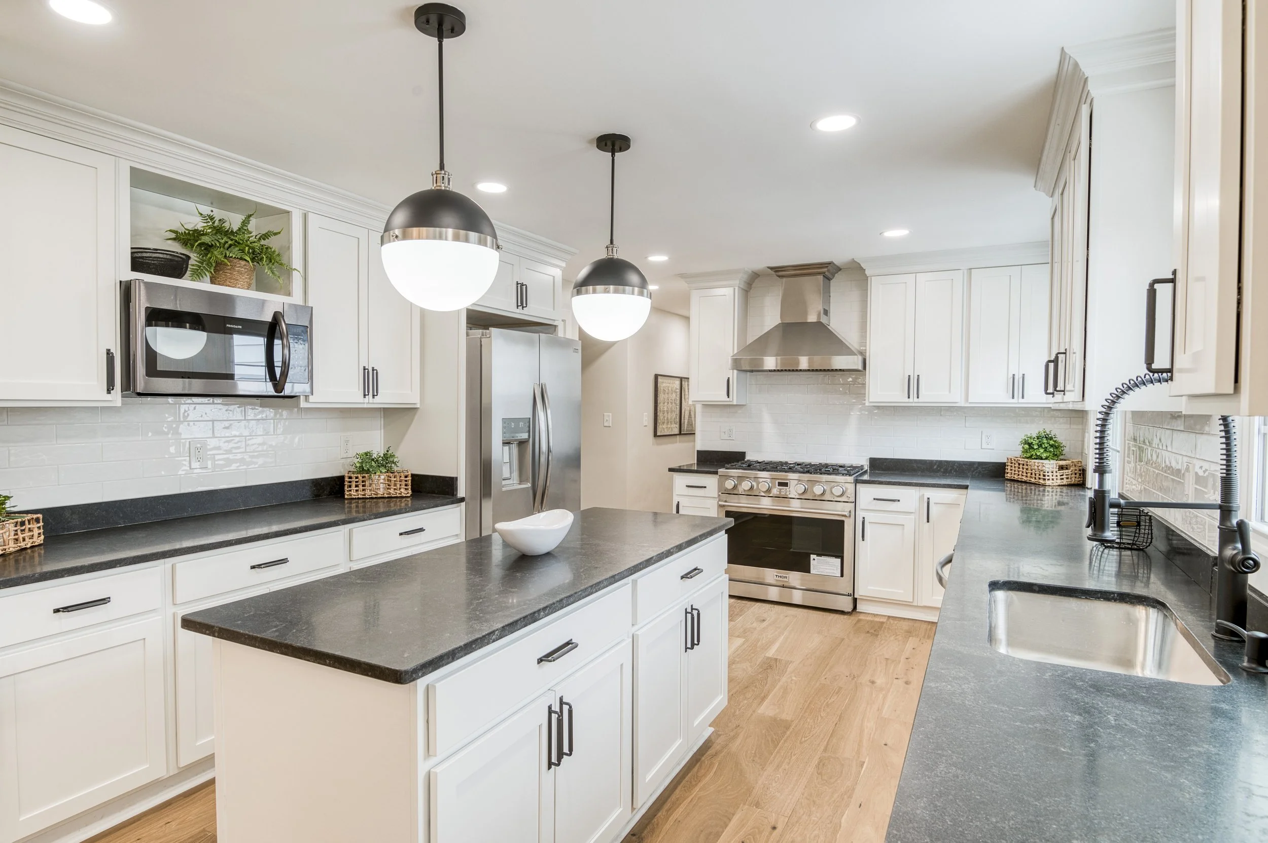 Modern white kitchen remodel with quartz island and matte black hardware by VNTG Home in Cleveland, Ohio.