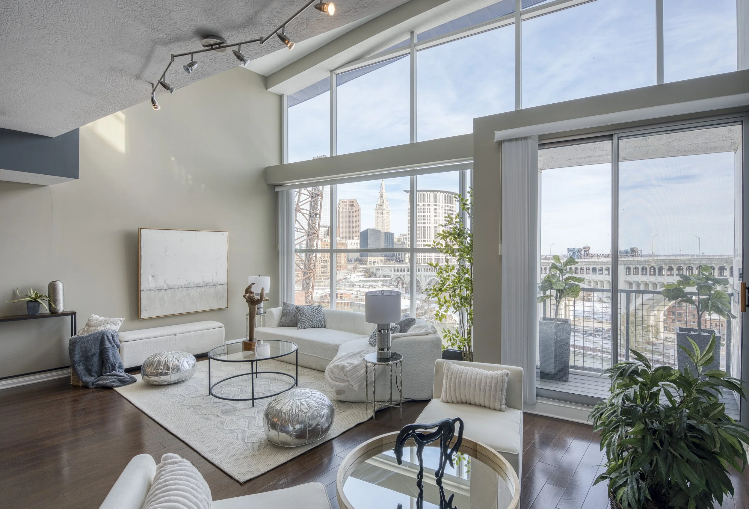 Modern downtown Cleveland loft with floor-to-ceiling windows, skyline views, and neutral contemporary staging by VNTG Home
