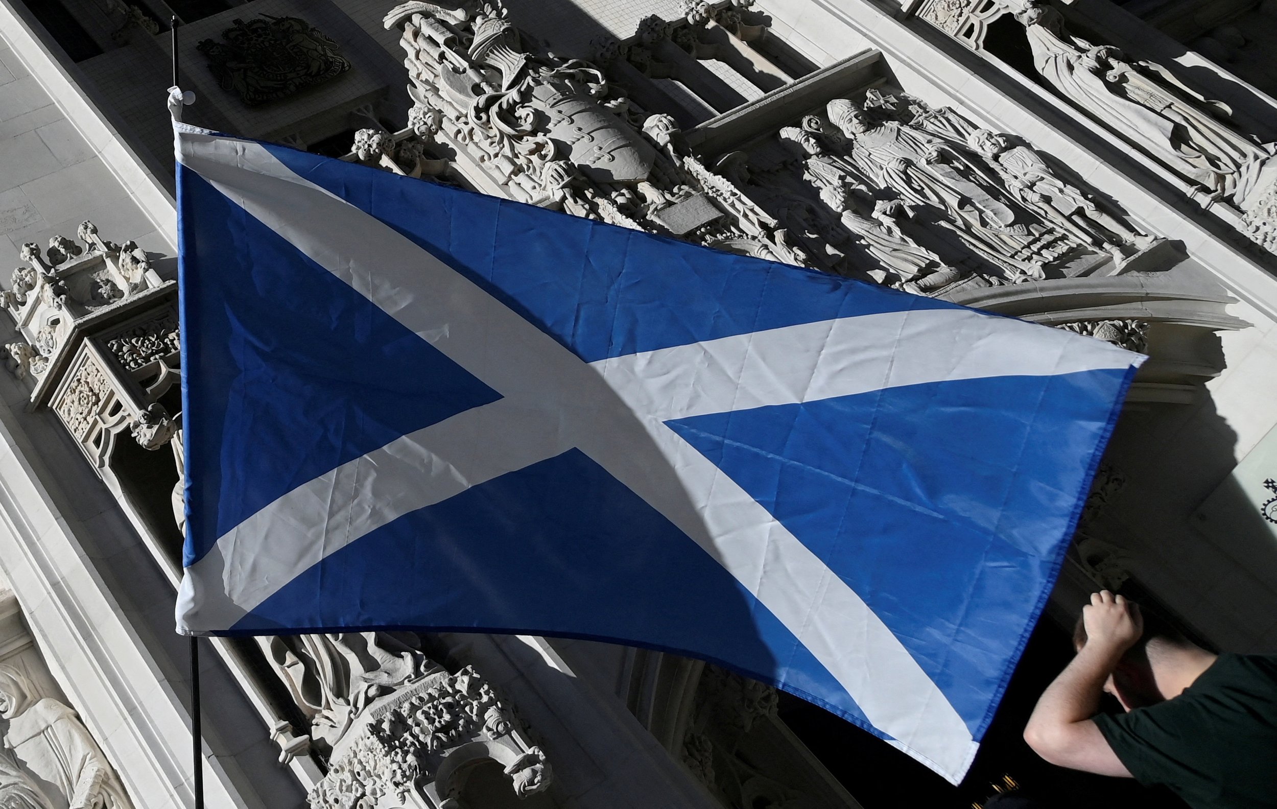 A Scottish Saltire flag is flown as pro-Scottish independence campaigners protest outside of the United Kingdom Supreme Court