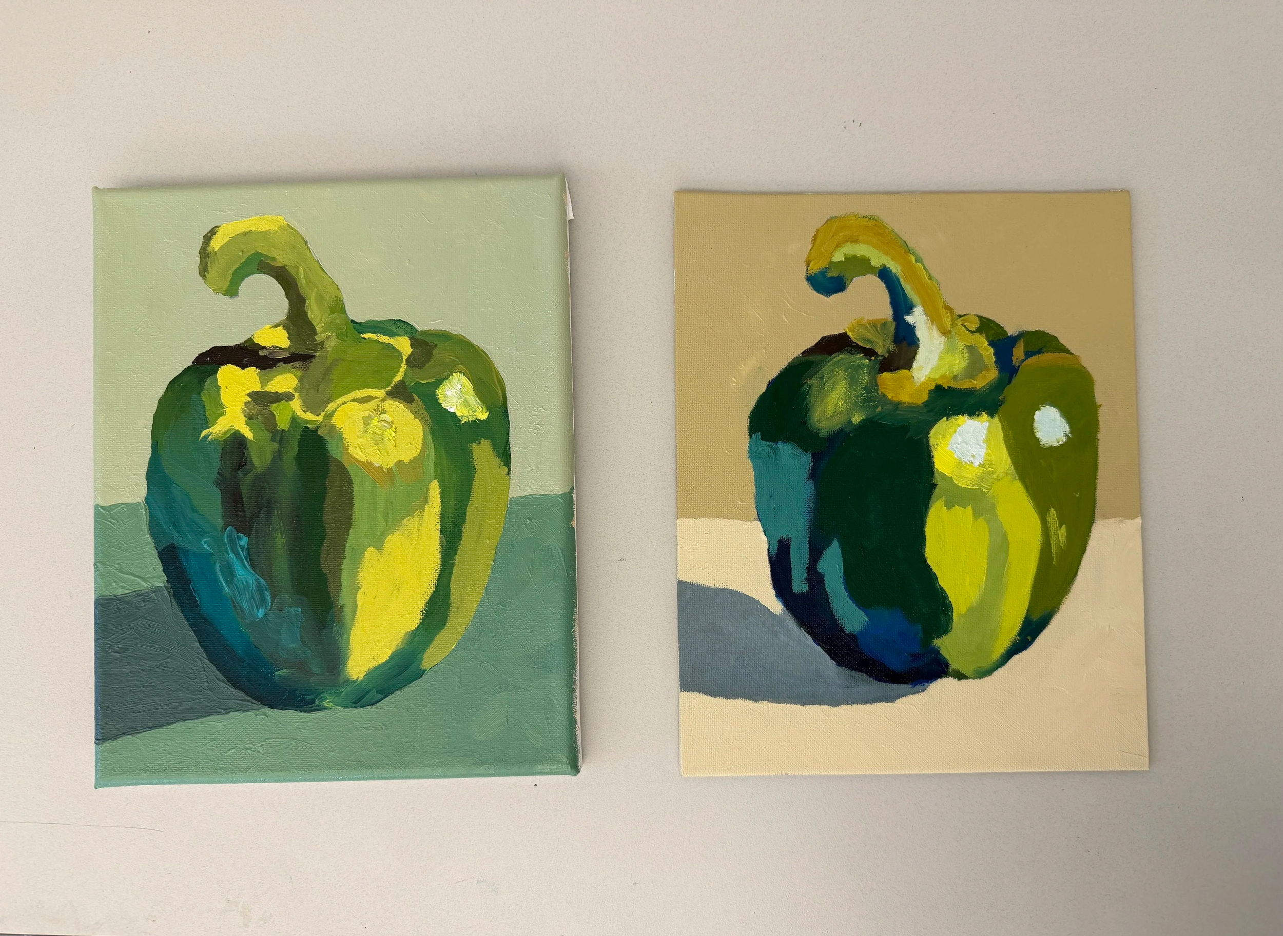 Two abstract paintings of peppers on a white wall, one with a green background and the other with a beige background.