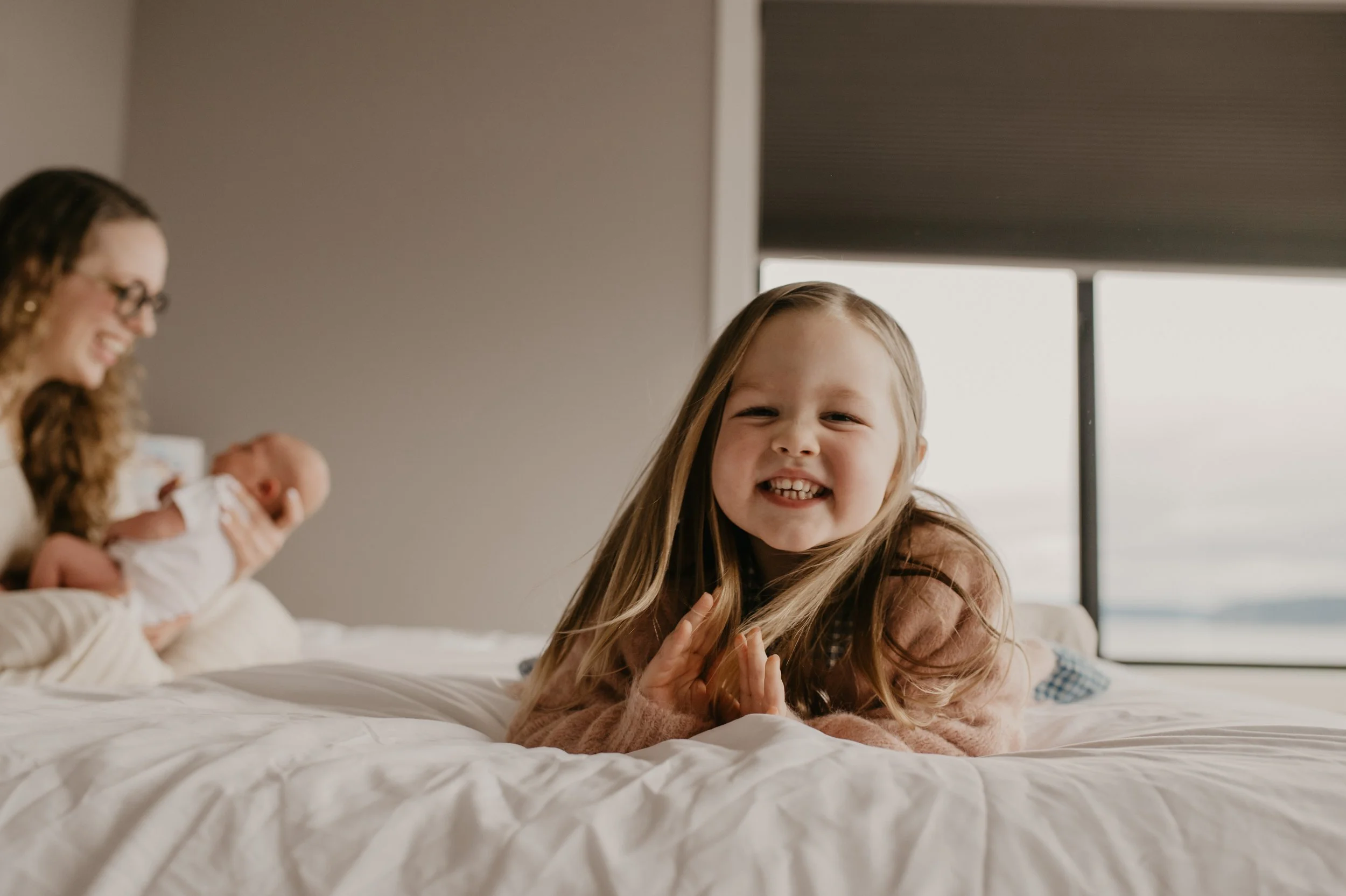 newborn session in family home older sibling laughing 