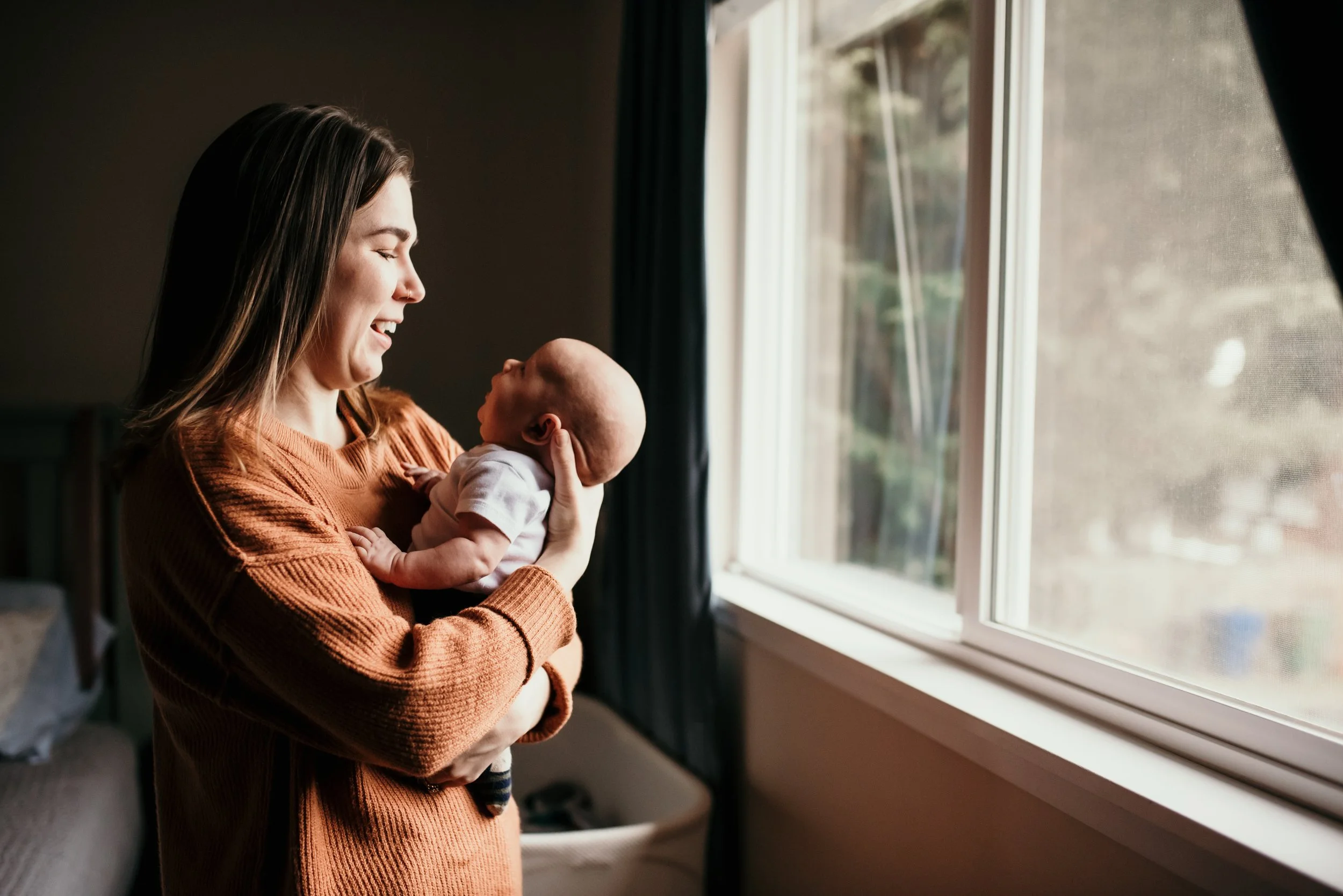 baby looking at mama in window newborn photography