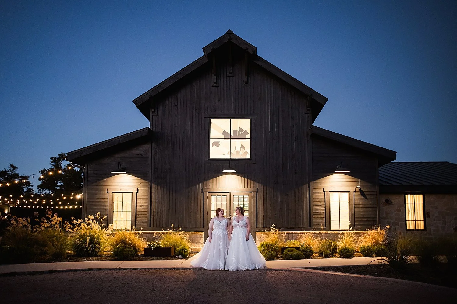 brides stand in front of barn at Morgan Creek venue