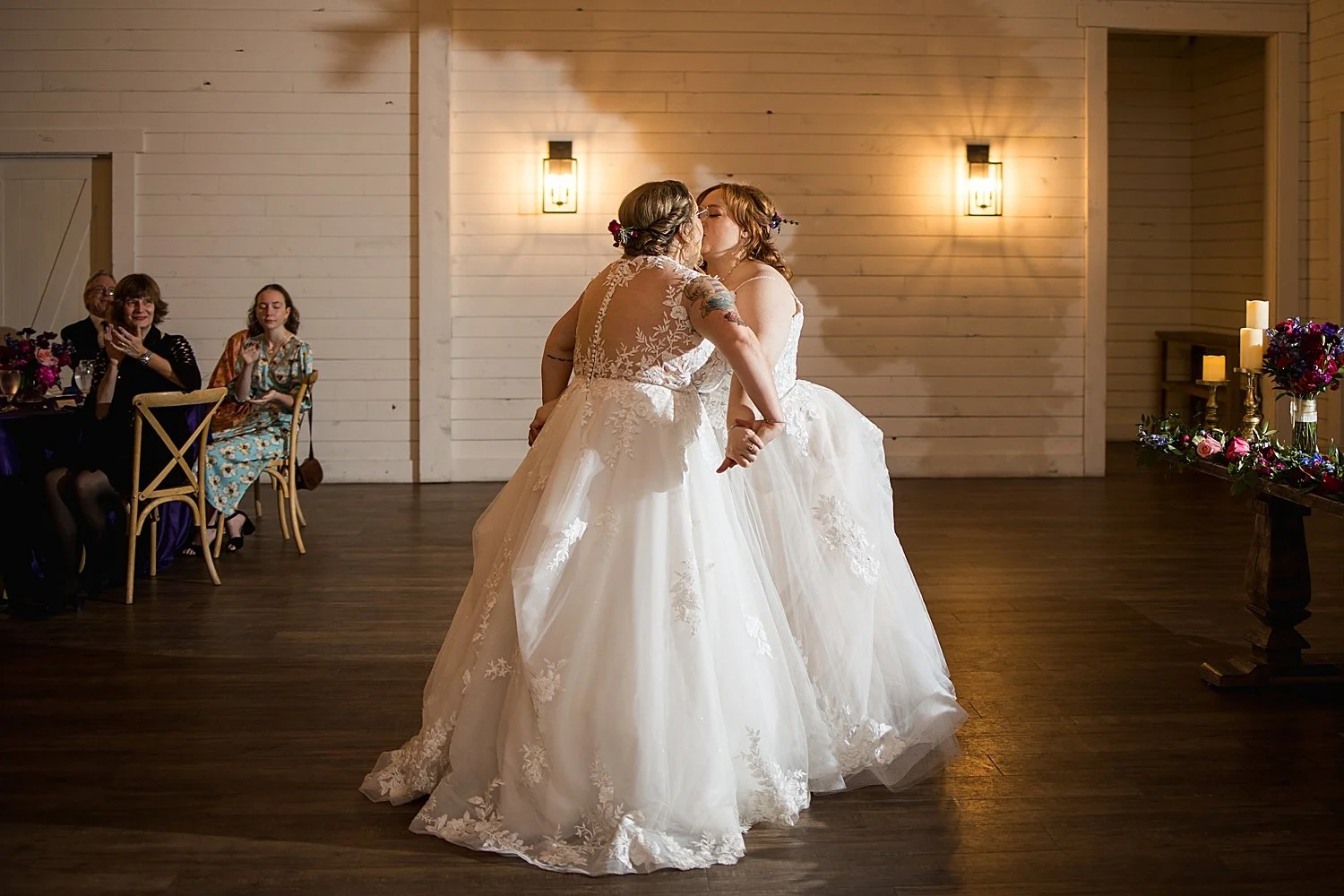 two women in white gowns dance at reception by Dripping Springs wedding photographer
