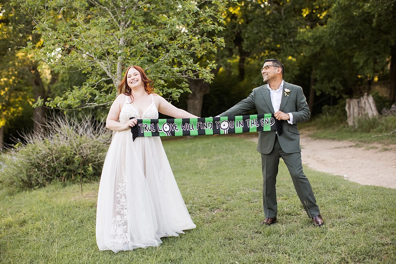 newlyweds hold up scarf for Austin FC at The Waters Point