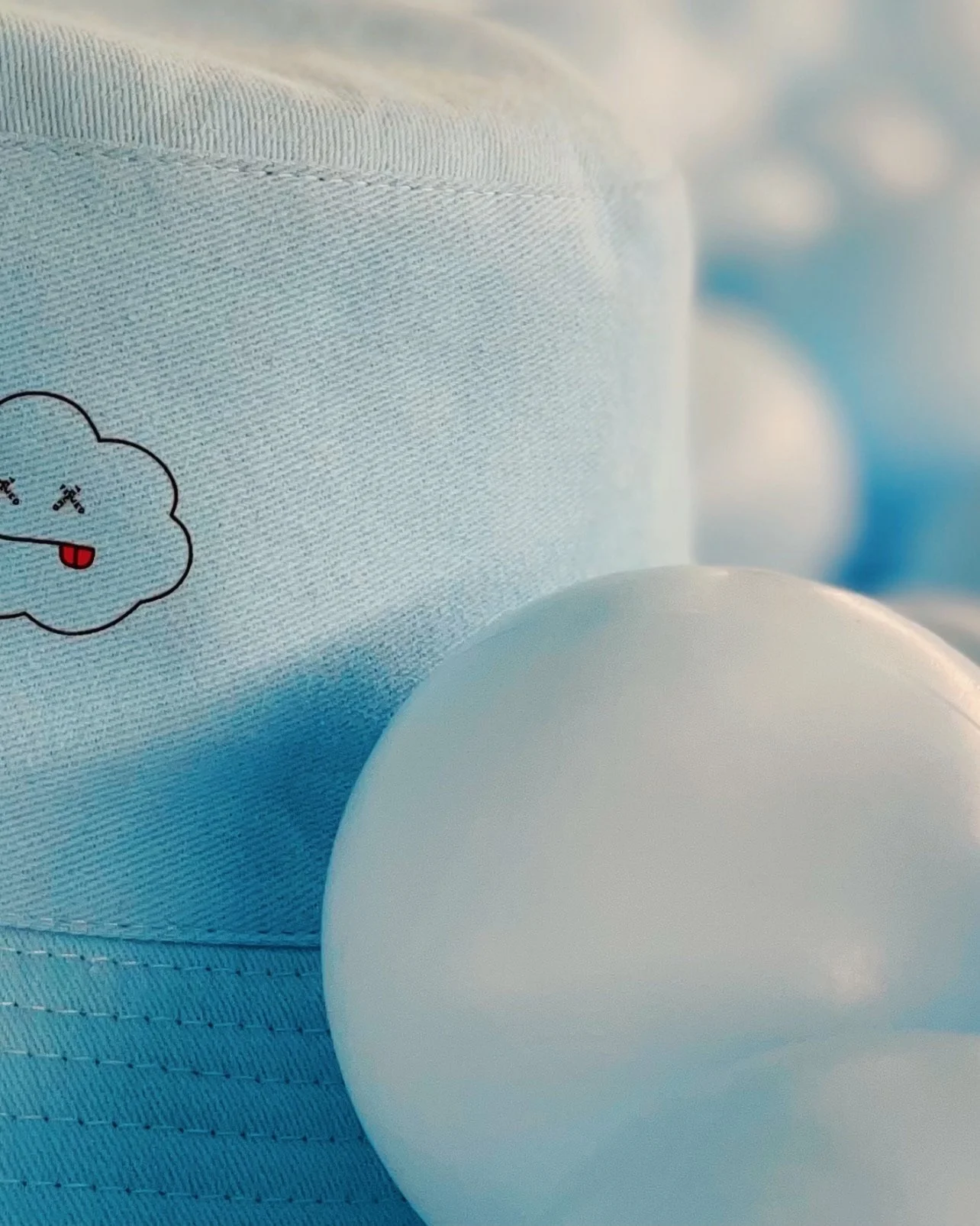 Close-up of a disposable diaper with a cloud-shaped cartoon sticker and a white plastic object in the foreground.