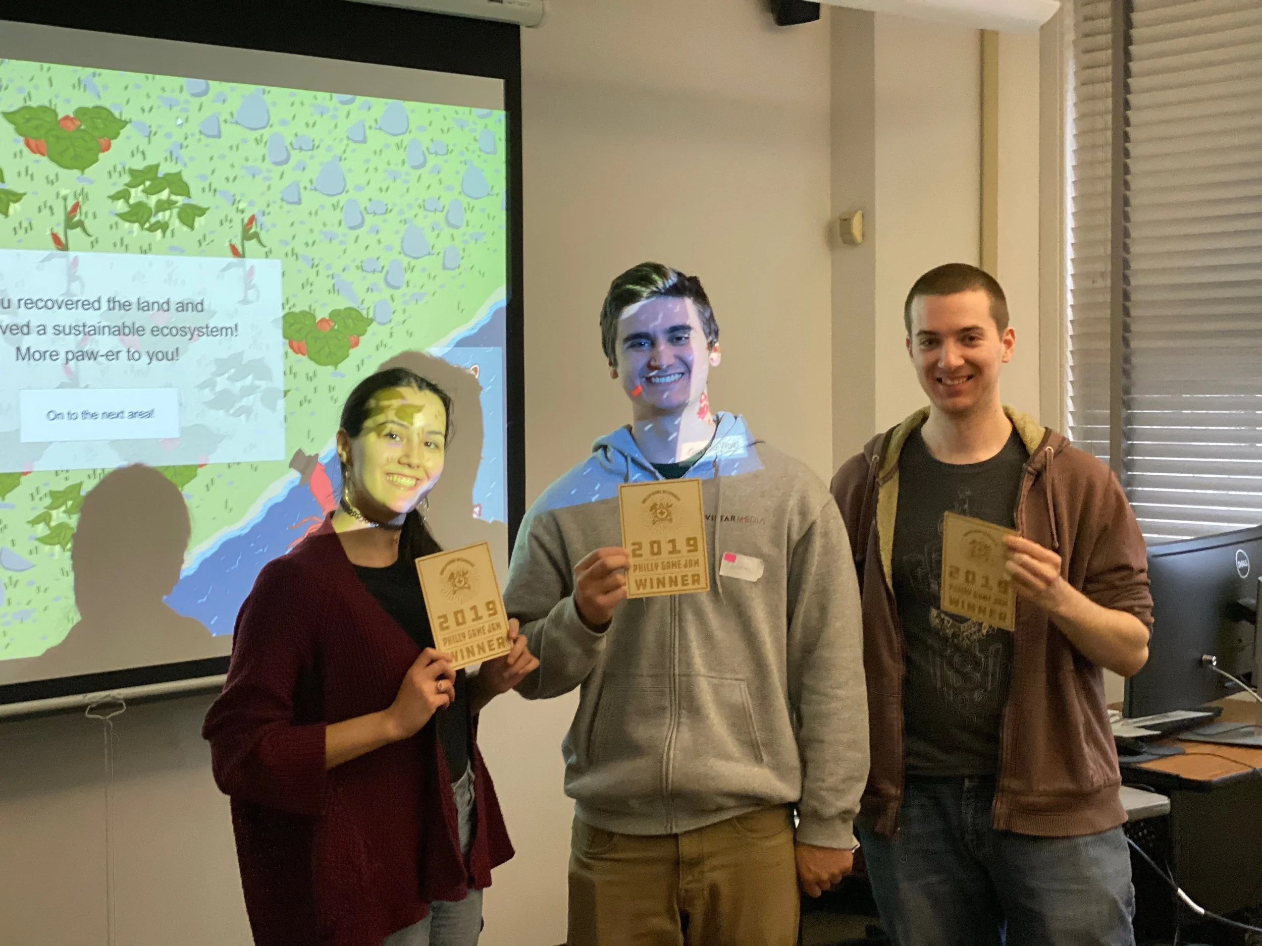 A photo of Nooka and two other men each holding a "Philly Game Jam 2019" award