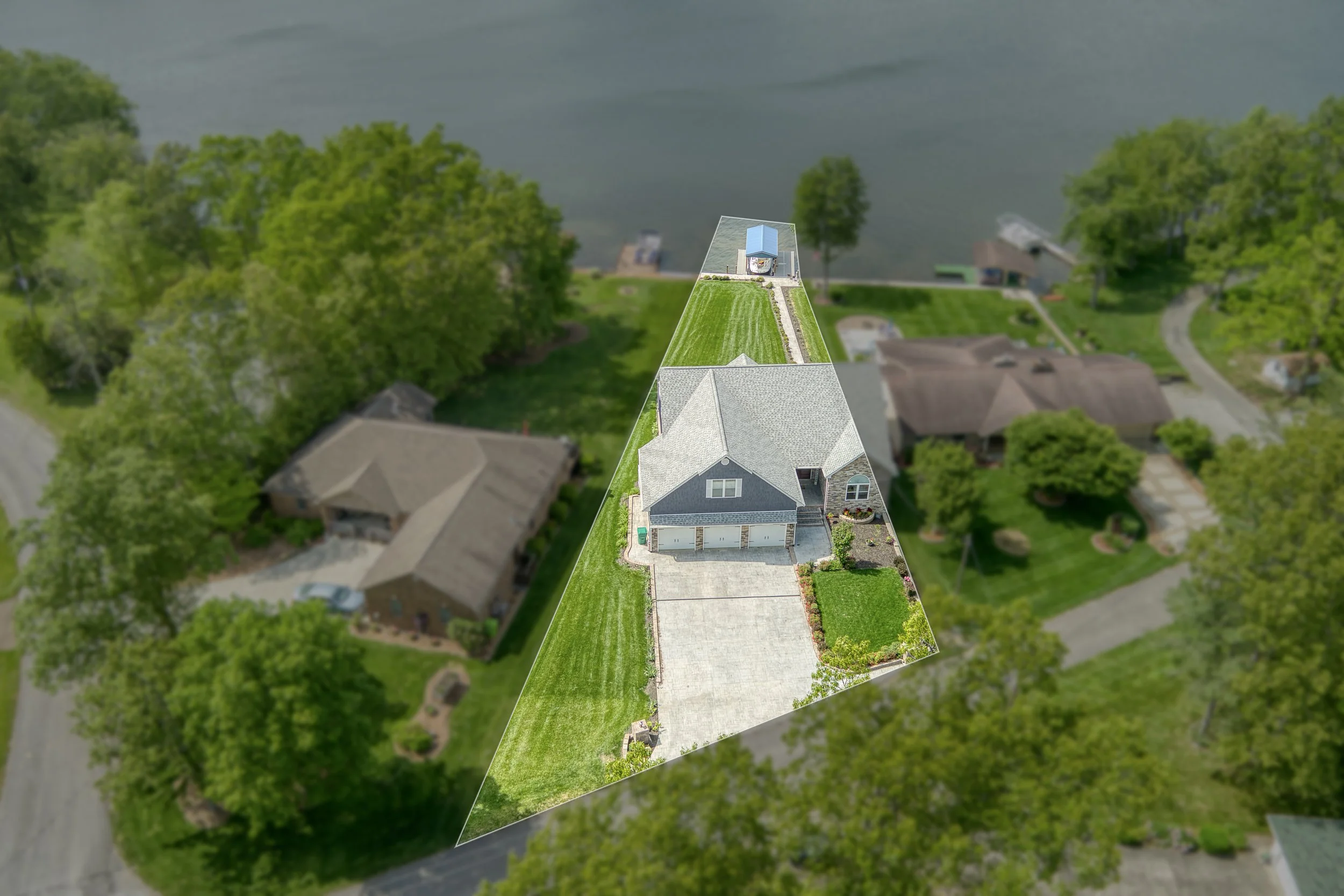 Aerial view of a residential backyard with a house, driveway, lawn, and trees, with part of the backyard highlighted and isolated for focus.