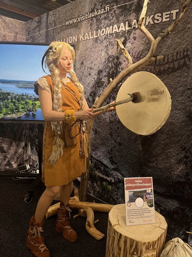 Helsinki travel fair 2025 - Laukaa & Peurunka booth design. Sarâ-mascot outfit design & creation. Sarâ copyright Erika Reponen. Actress Milla Nieminen. Shaman drum & rack by Antti Rauhala.