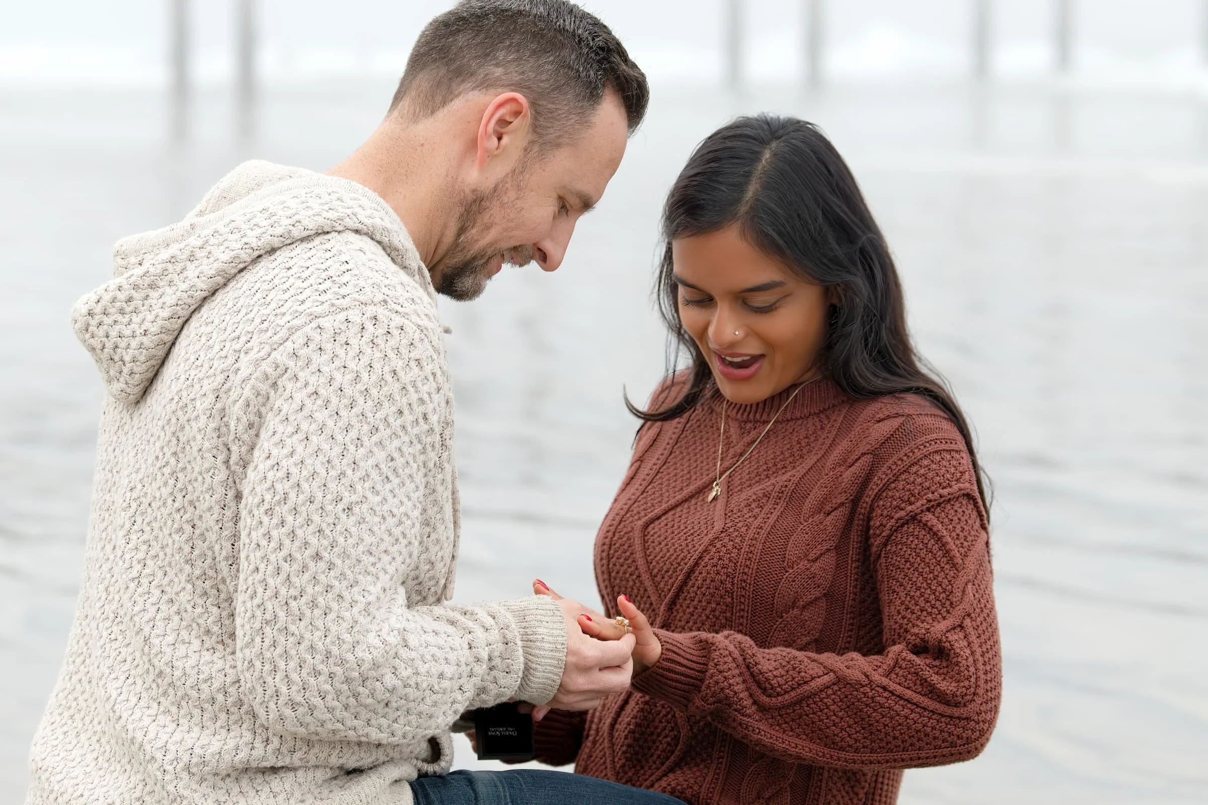 A man proposes to his fiancée at La Jolla Shores