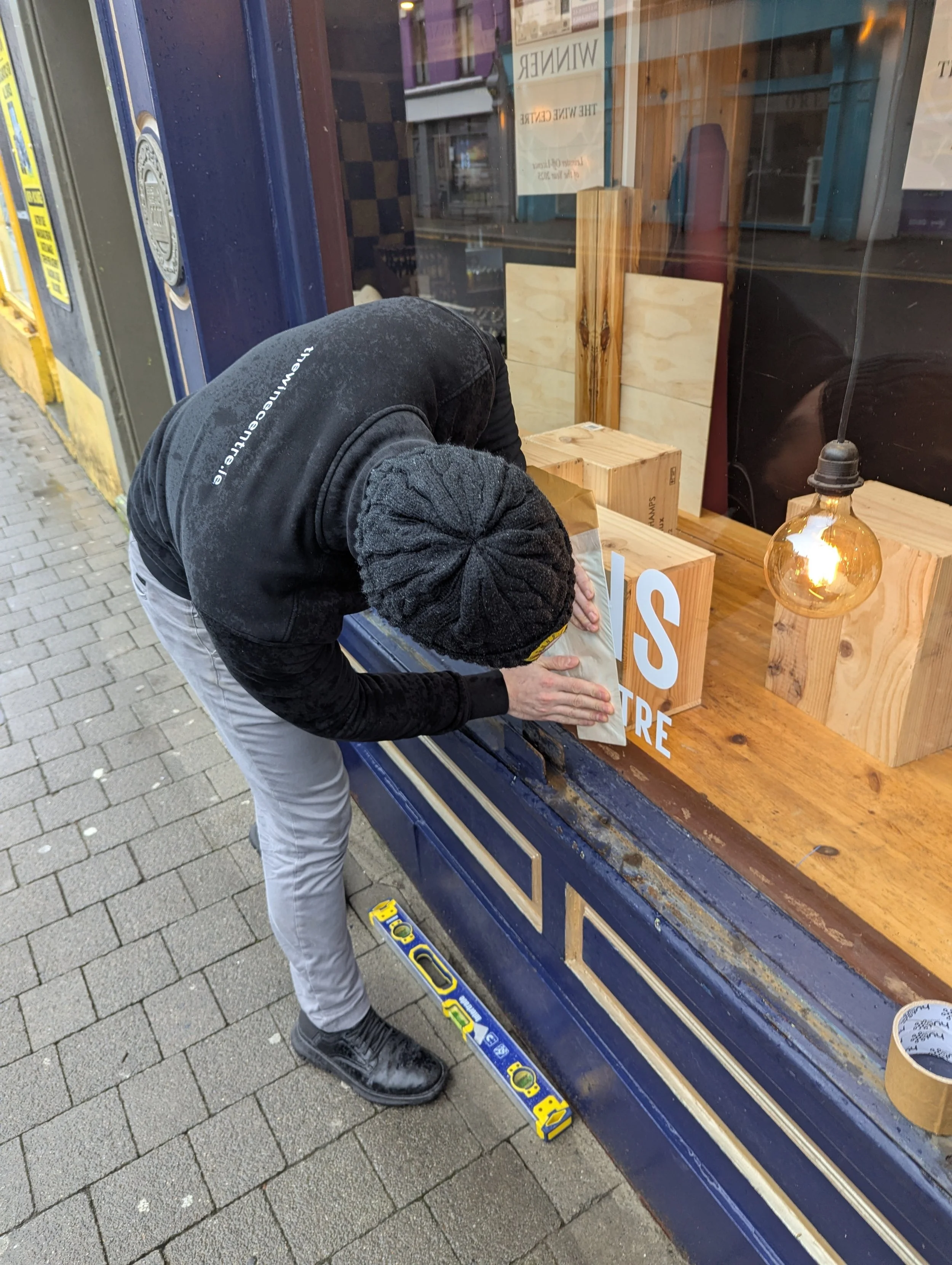 Retail staff member receiving hands on vinyl decal training as part of a visual merchandising workshop.
