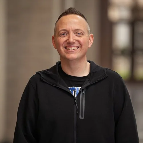 Smiling person wearing a black hoodie