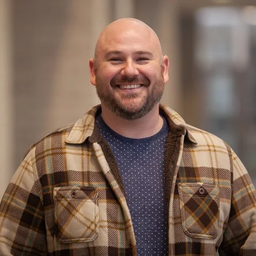 Smiling man in plaid jacket indoors