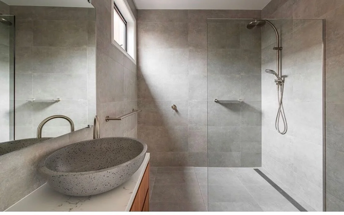 The elegant Arkistar concrete look tiles from @rivoland_tiles, timber vanity and spacious design of this Turner bathroom combine to make a lasting impression.