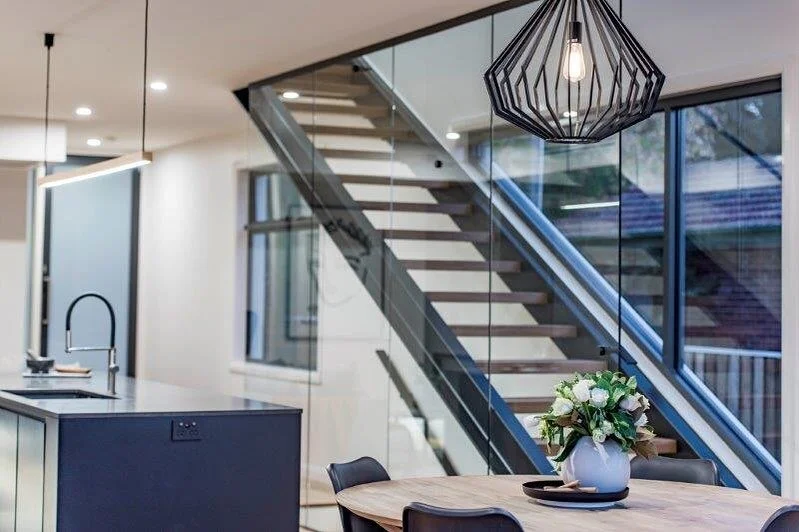 The use of a seamless glass wall in this stairwell allows the inside to be drenched with light. The staircase was designed to maximise the feeling of space and openness, creating a beautiful space to live in.