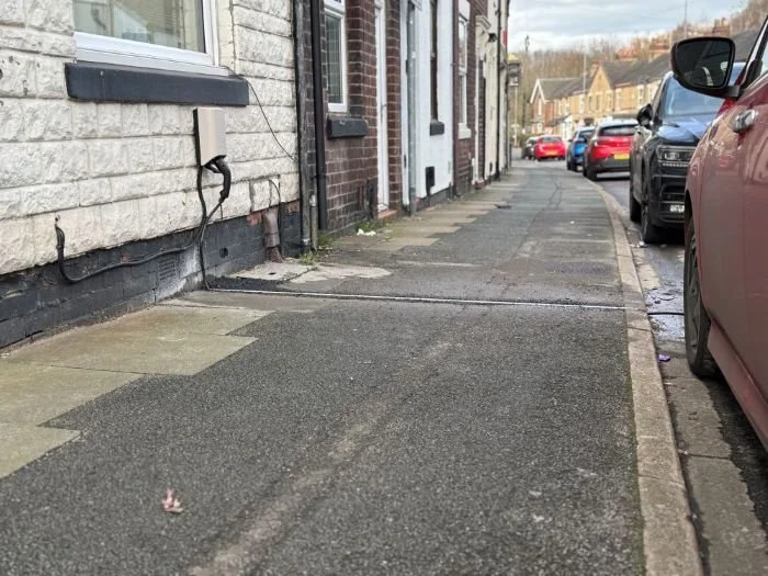 EV cable gully in pavement outside terraced house runnning from the outside of the house to the edge of the kerb
