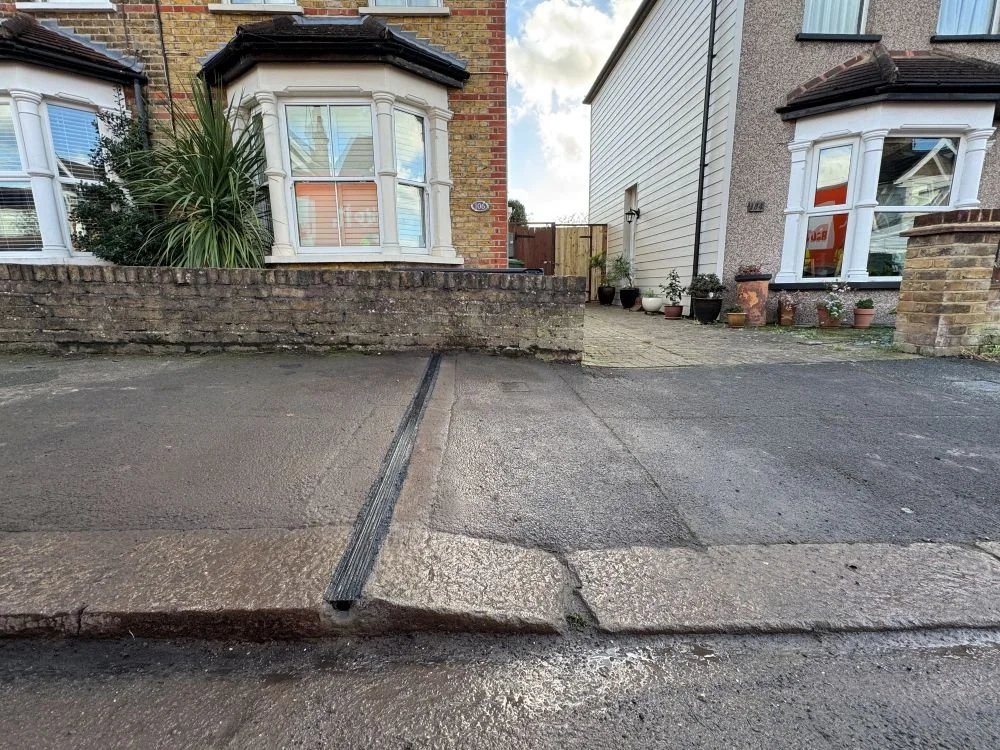 EV Cable channel in pavement outside house with bay window