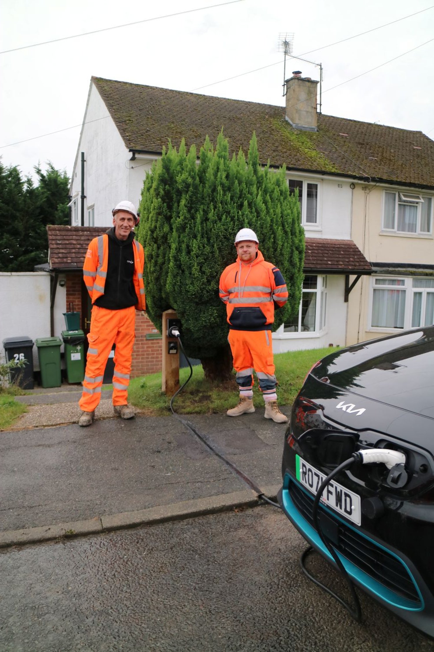 Two installers in high vis standing next to Kerbo Charge EV cable channel