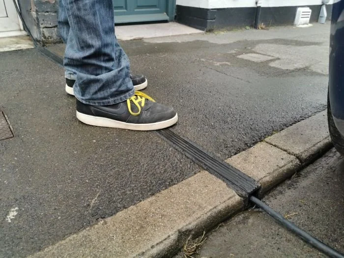 person standing on EV cable gully