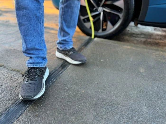 Feet standing on top of Kerbo Charge EV Channel in pavement
