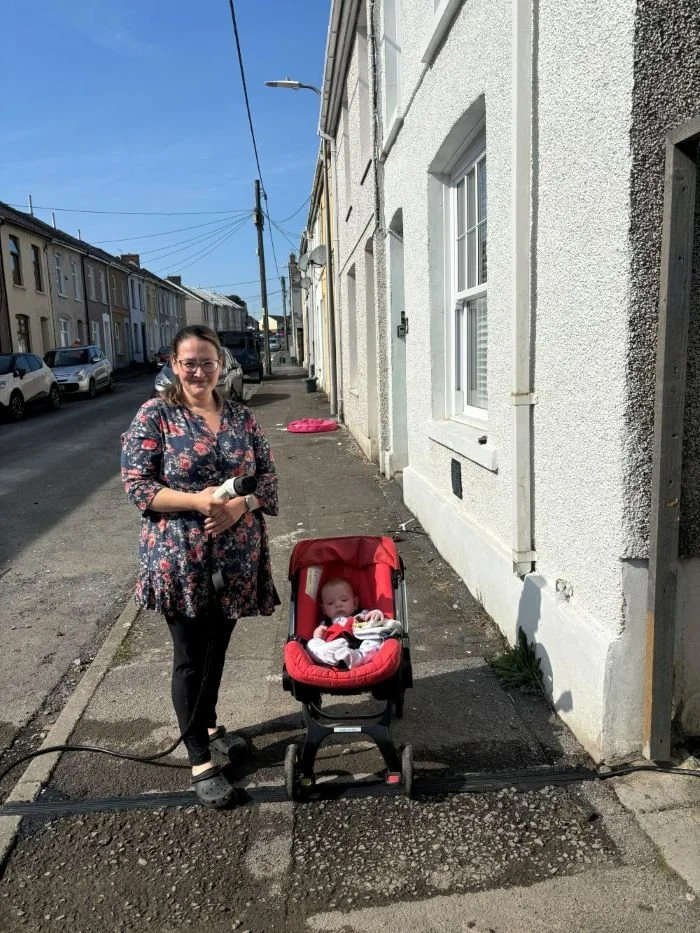 Woman and Baby in a pushchair in pavement with newly installed EV cable gully