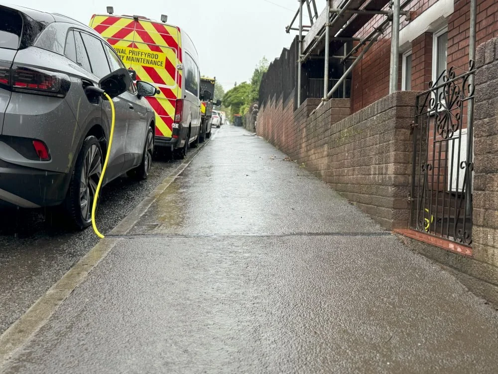 Grey EV being charged at home with on-street parking