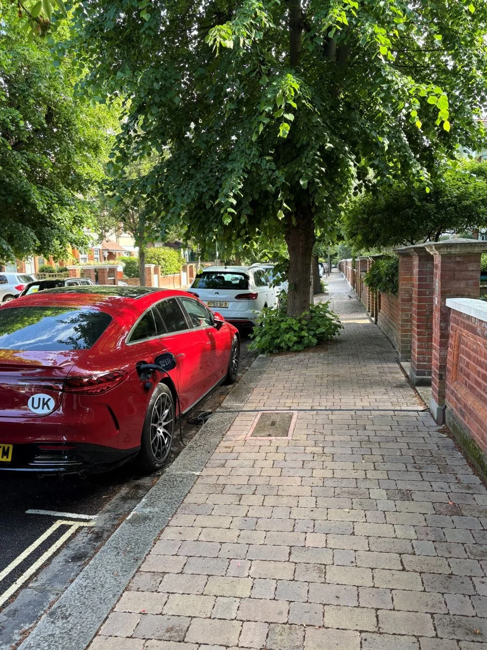 Car being charged on the street via a EV cable gully