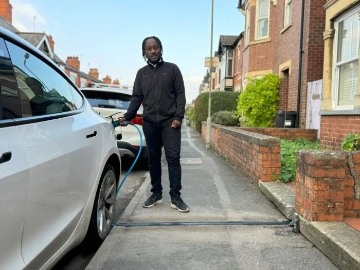 man charging car using EV cable channel on Milton Keynes street