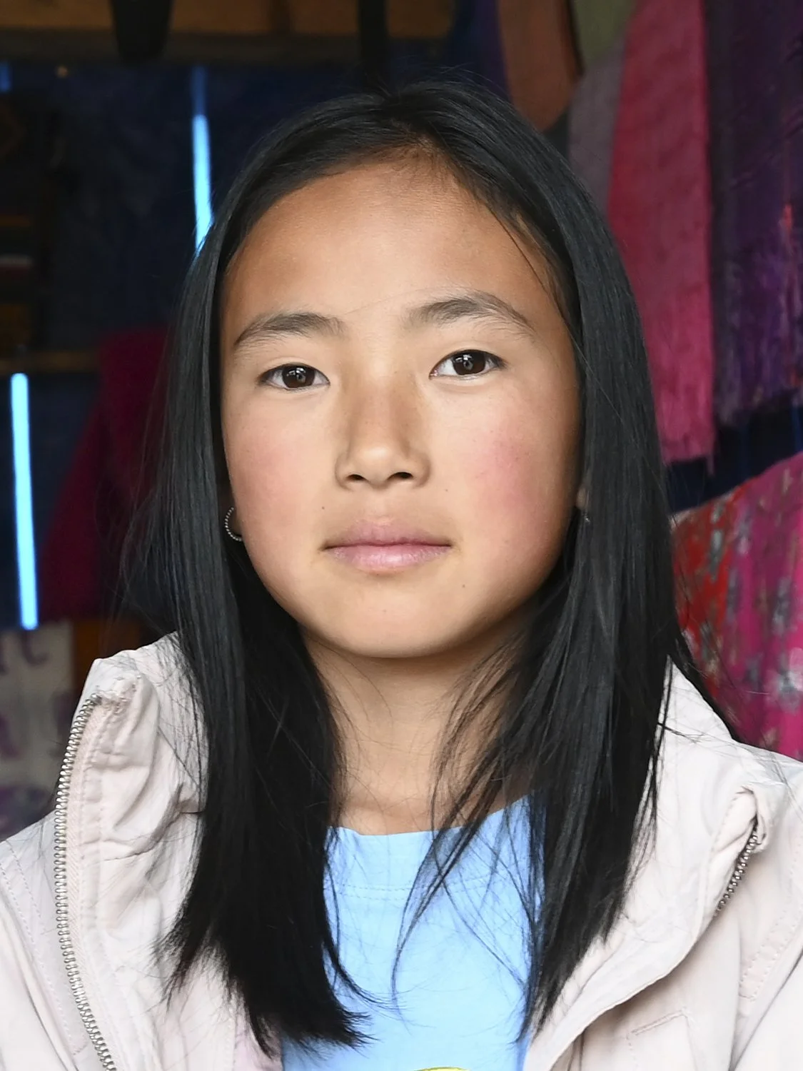 A young woman is selling scarves in her family's traditional business. Phobjikha Valley, Central Bhutan