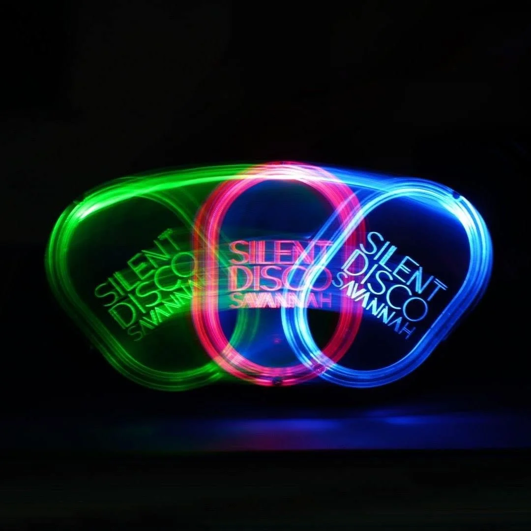 Colorful neon light rings with the words "SILENT DISCO" and the name "SAMMAY" repeated inside each ring, against a black background.