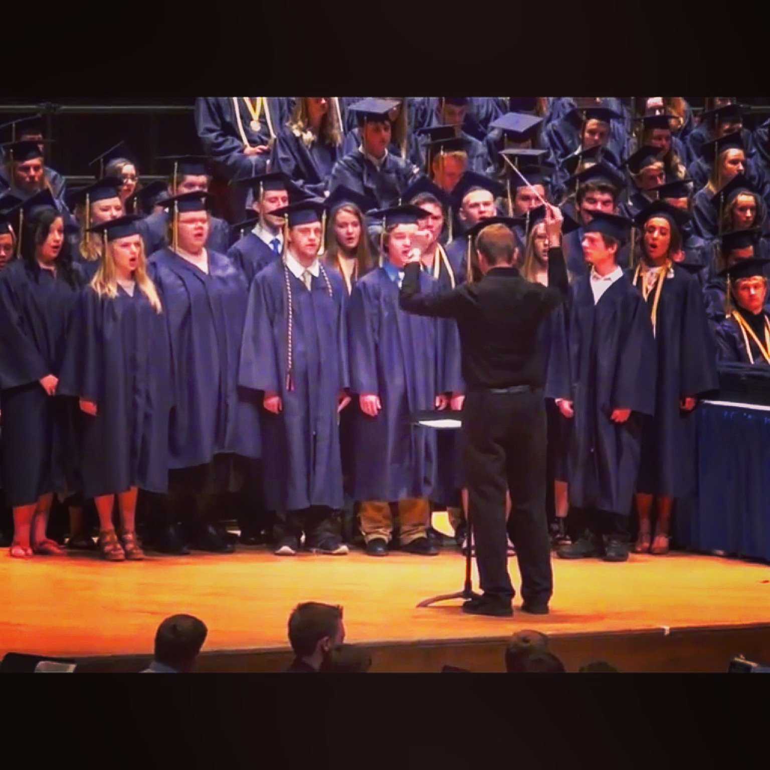 Parker MacIver Hinnenkamp conducts the senior choir during graduation in the DECC's Symphony Hall. Class of 2015.