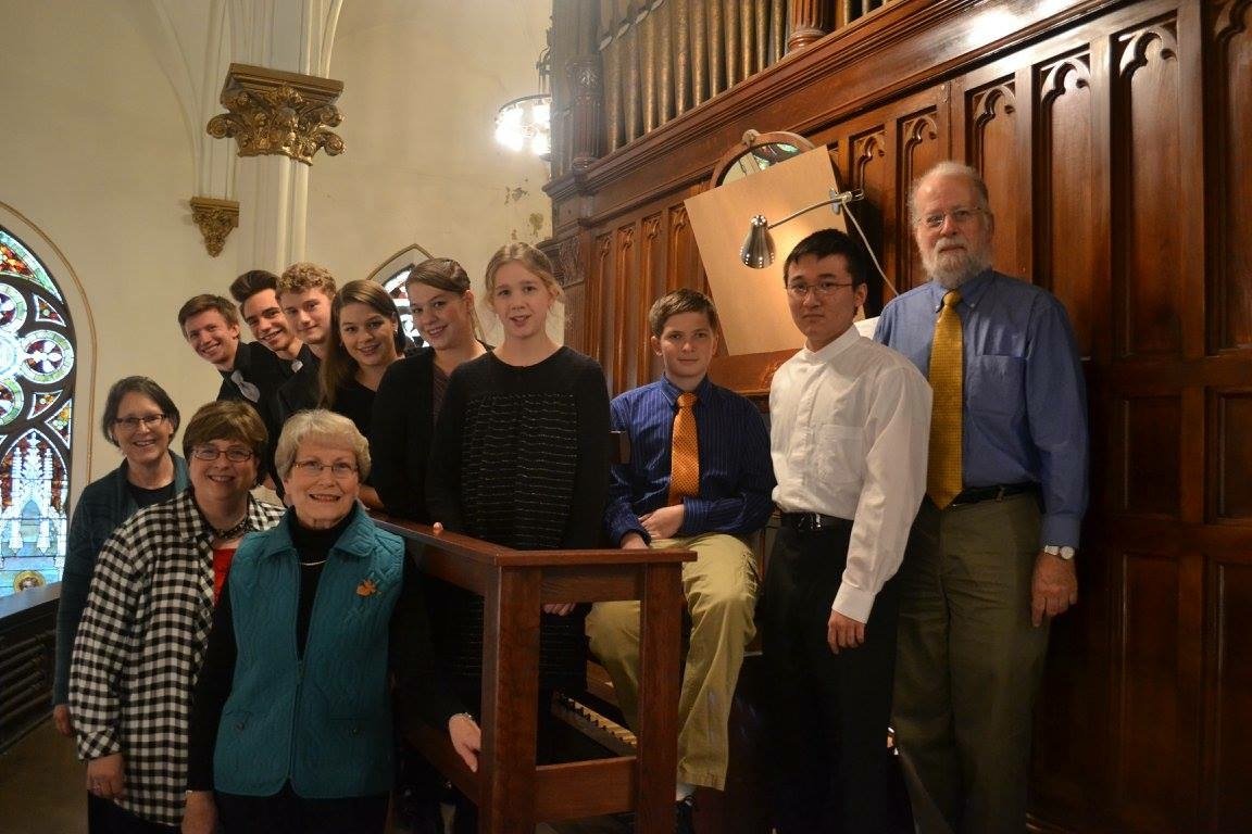 Parker MacIver Hinnenkamp with Michael Barone and the Arrowhead Chapter of the AGO's scholarship students at the keys of the historic Felgemaker organ in Sacred Heart Music Center before a group recital.