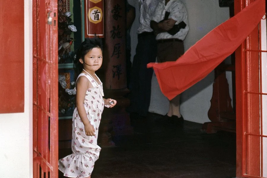 Young Chinese girl in front of the Holy Triad Temple.