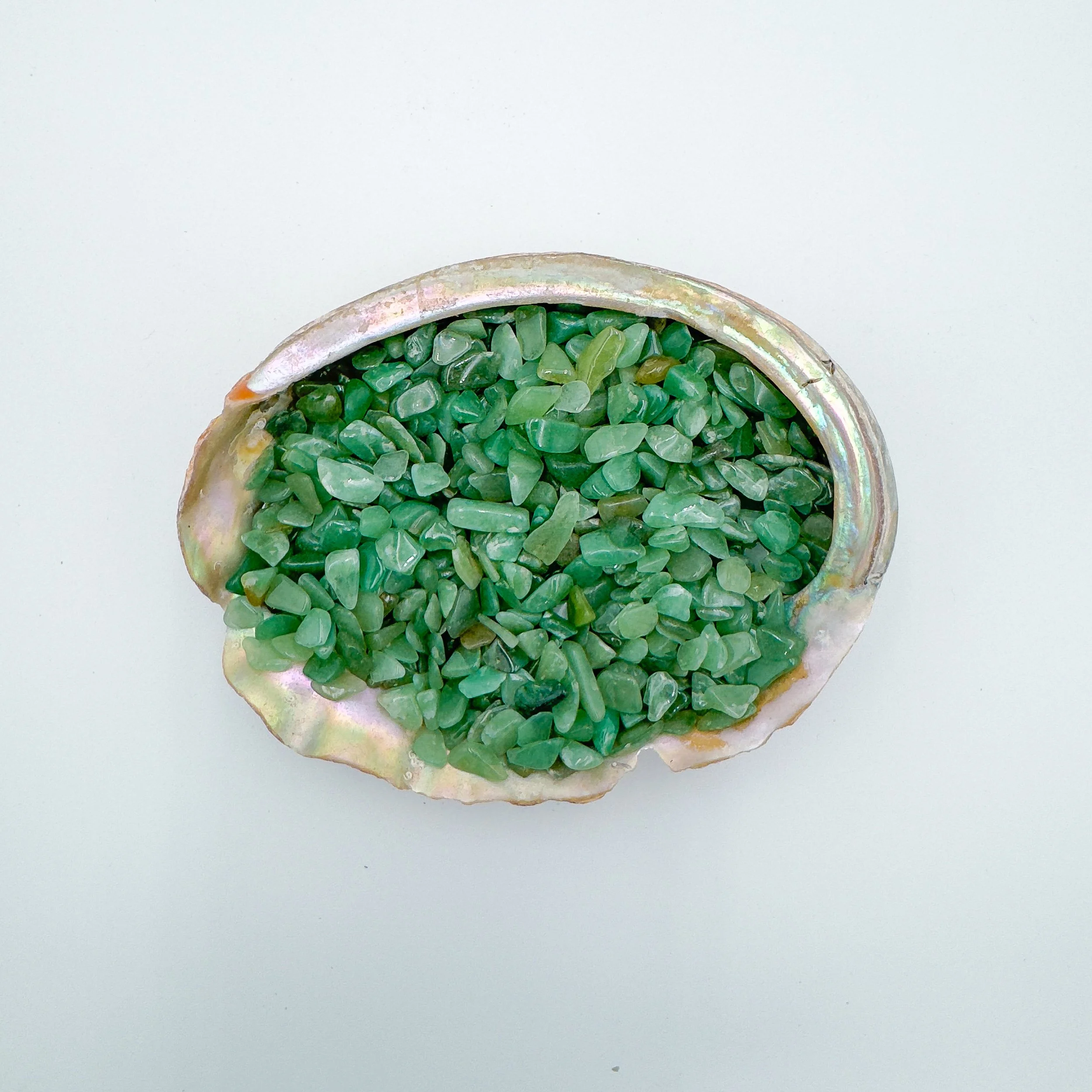 Polished Green Aventurine crystal chips in soft green hues, displayed in bulk for jewelry design, resin art, meditation jars, and decorative bowls.