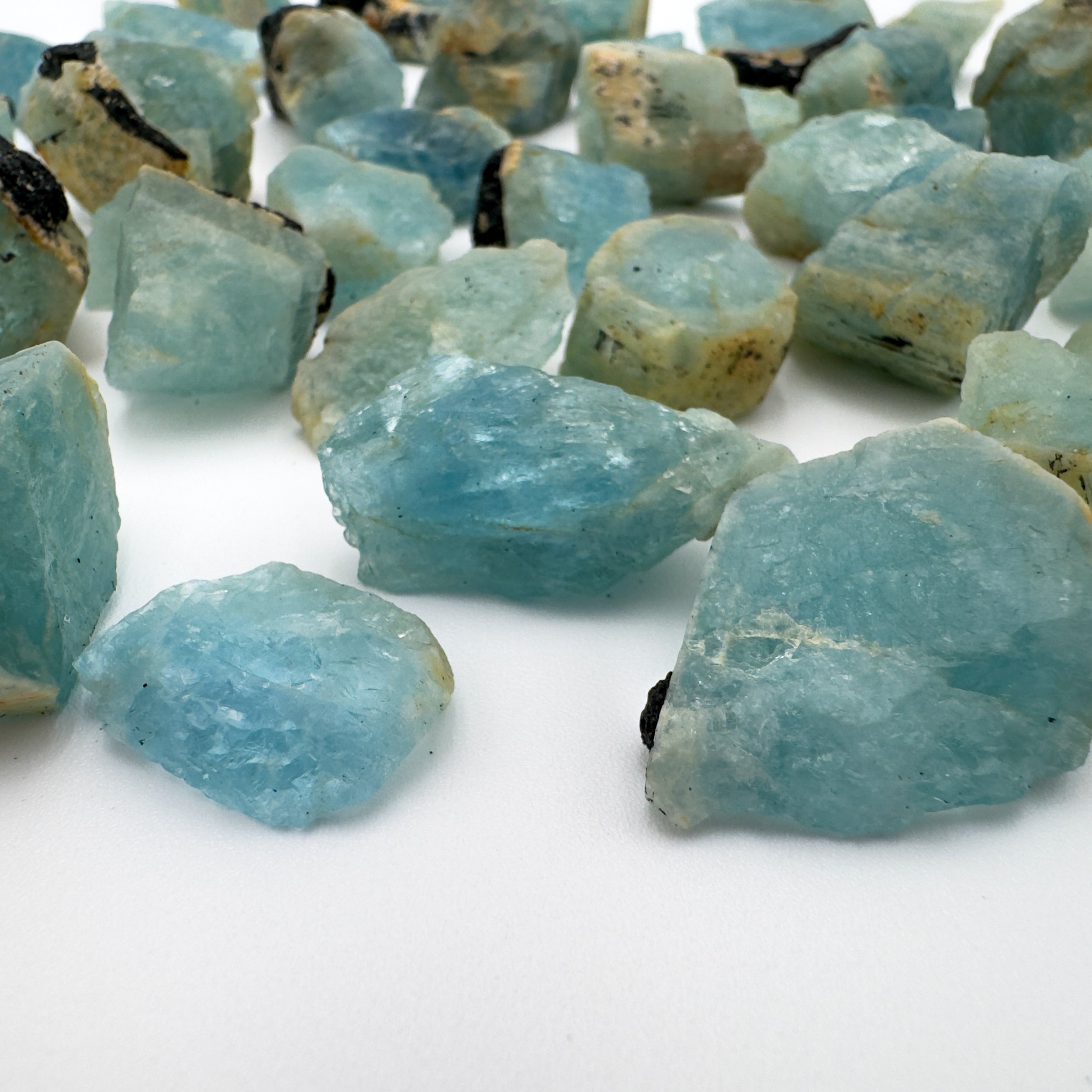 Ethically sourced small Aquamarine raw crystals with distinctive black tourmaline inclusions, perfect for metaphysical use and jewelry making