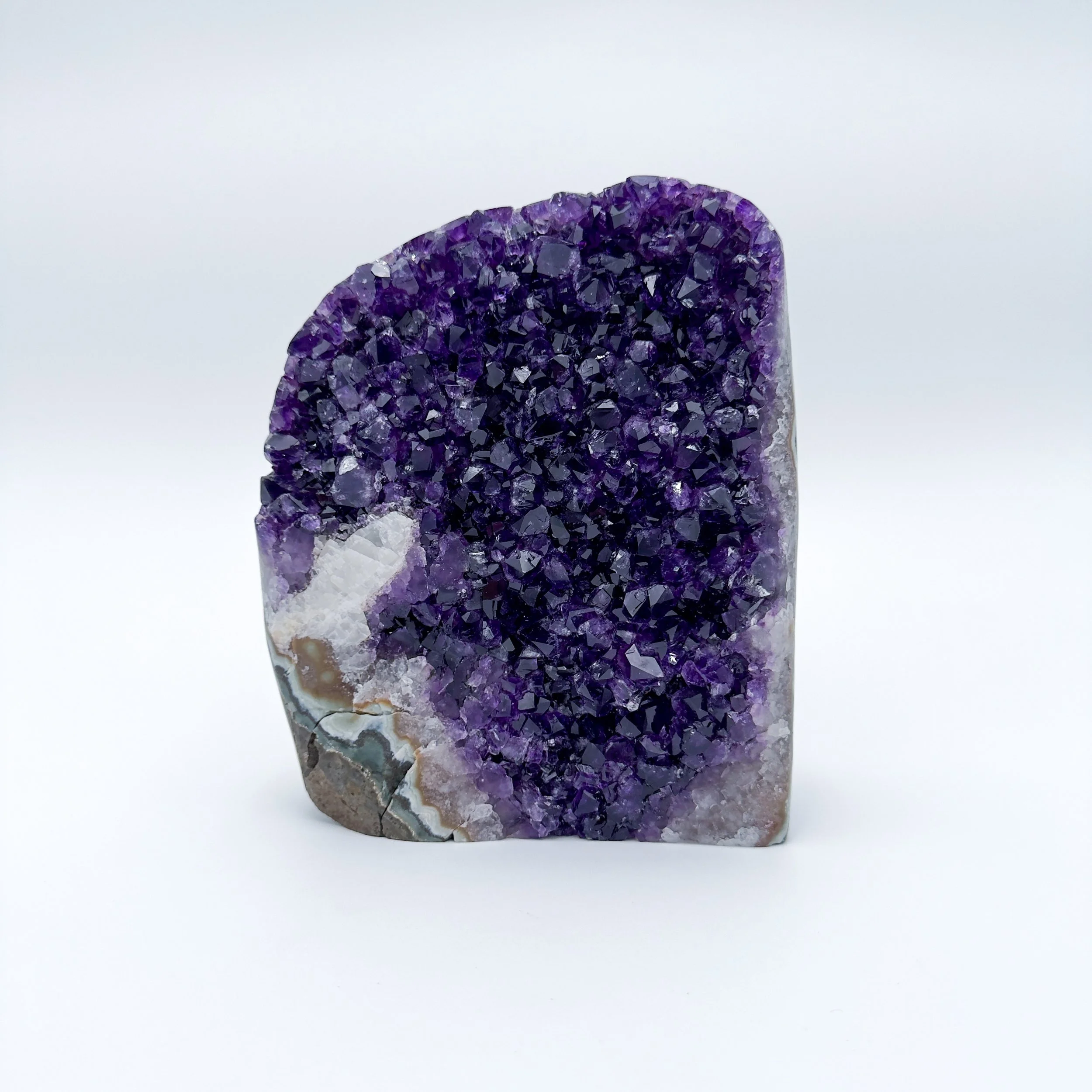 Polished Amethyst geode with deep violet crystals and natural banding