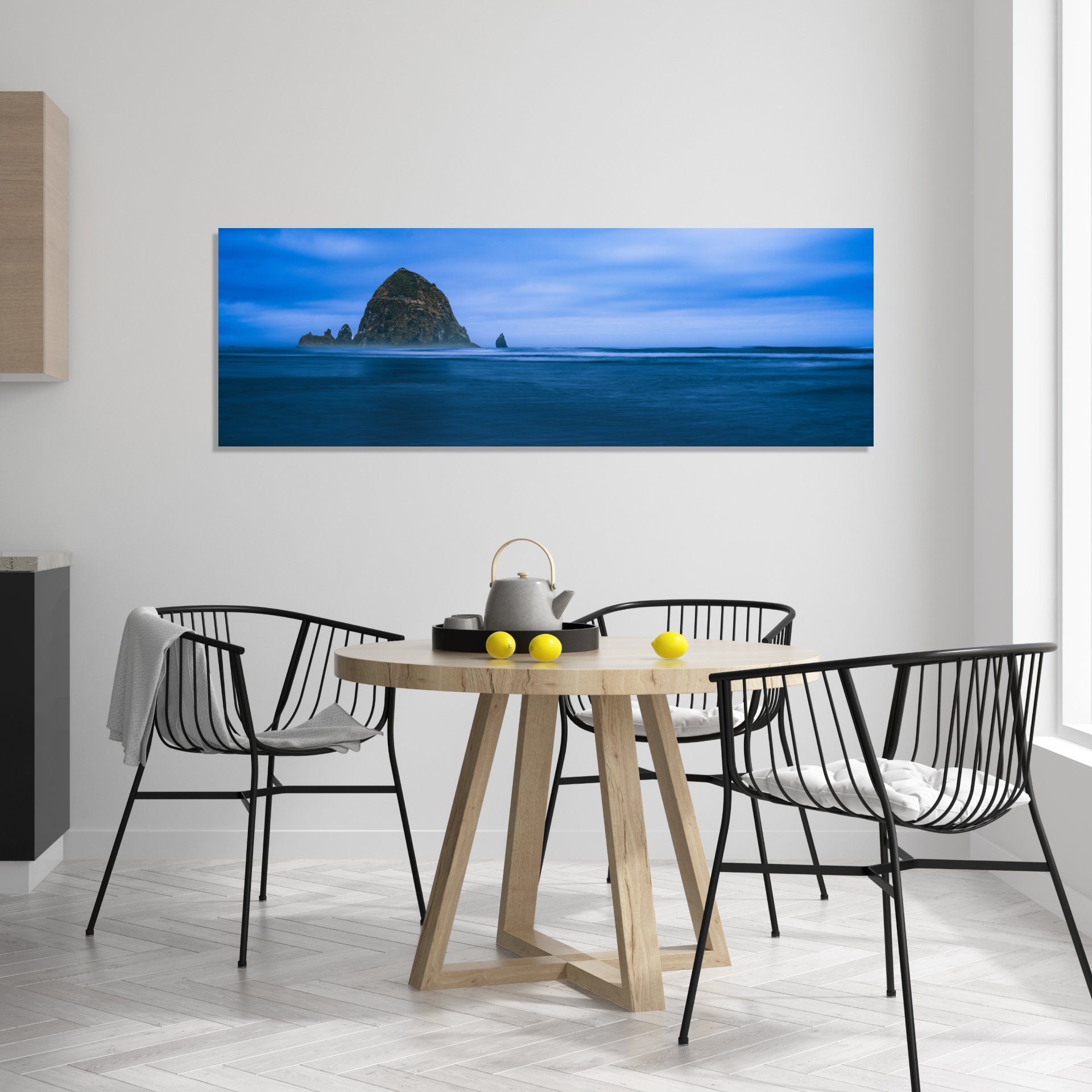 Iconic Haystack Rock emerging from a misty, blue ocean at dusk.