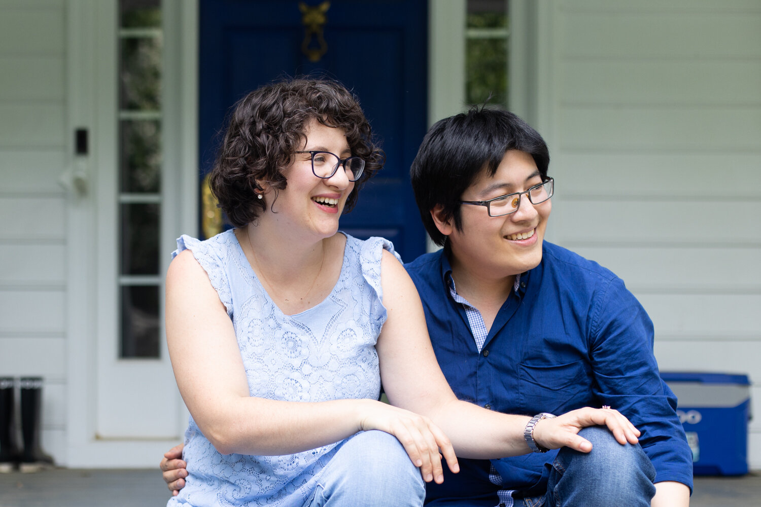 Couple laughing on front porch during family photos at their home in Richmond, VA