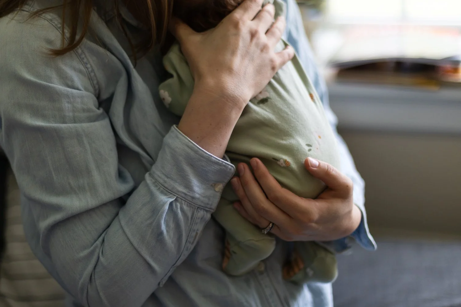 Mom holds her newborn baby in their Richmond, VA living room.