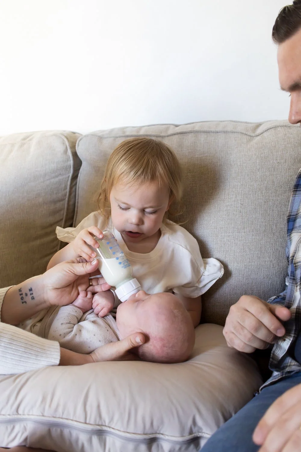 Sister feeding baby at home in Richmond