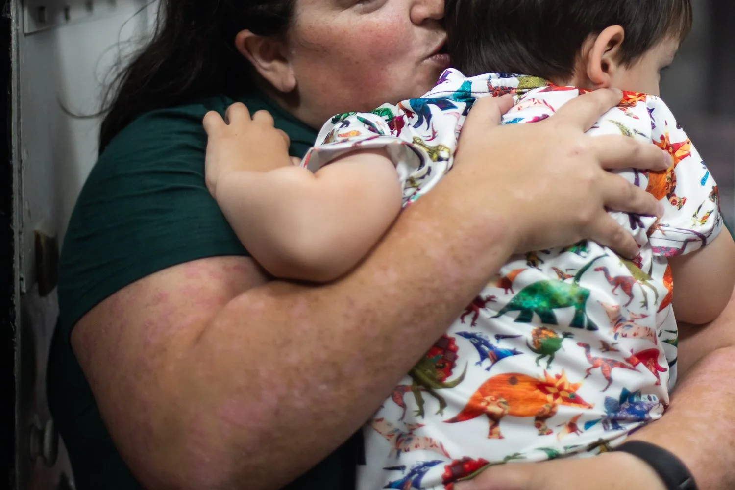 A mom kisses her toddler and holds him tight during a family photo session in Richmond, VA.