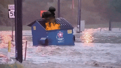 A flaming dumpster floating along a flooded city street, used as a metaphor for the previous paragraph about Career Day.