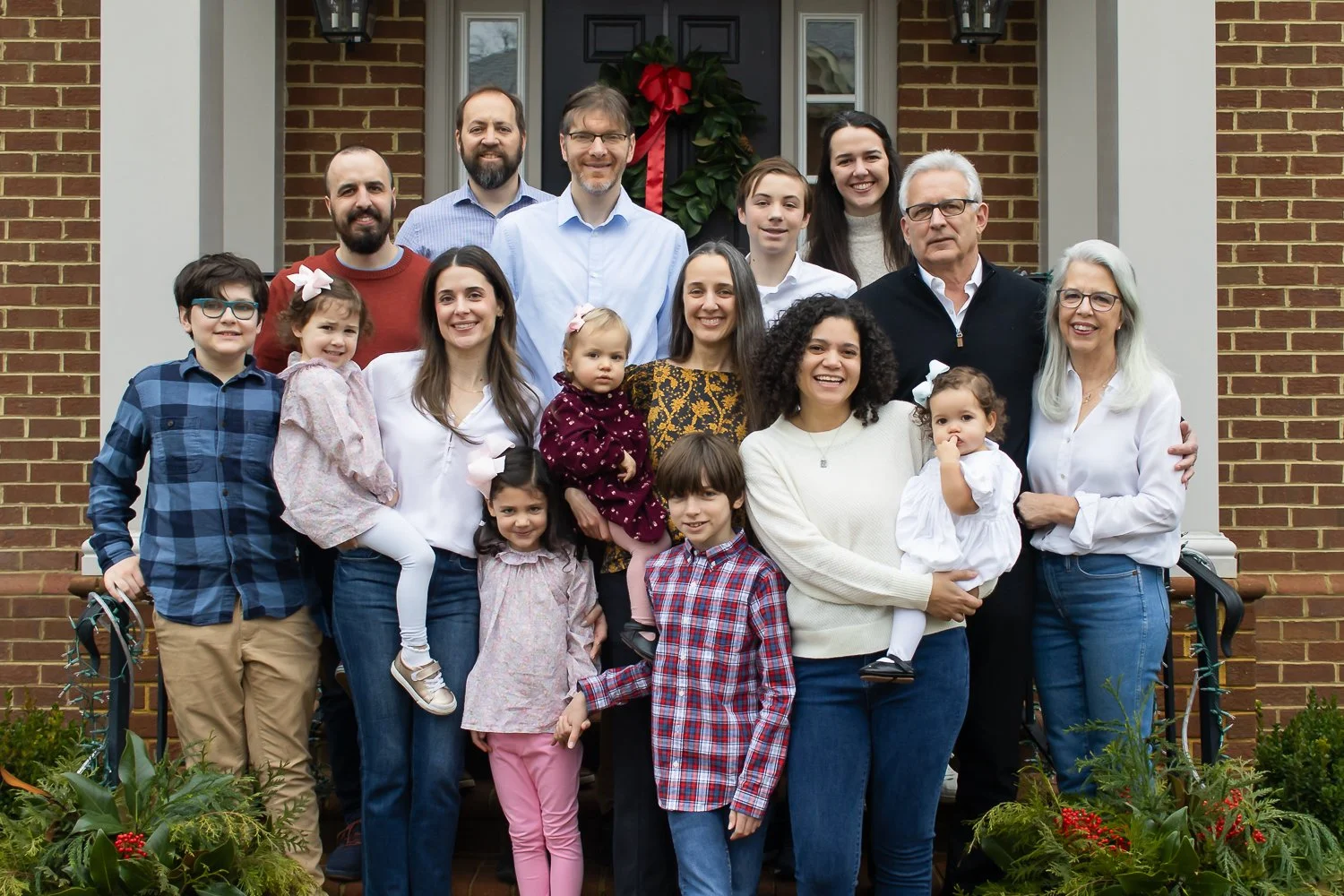 An extended family photo with multiple generations and many families together on the front porch of the grandparents' home.