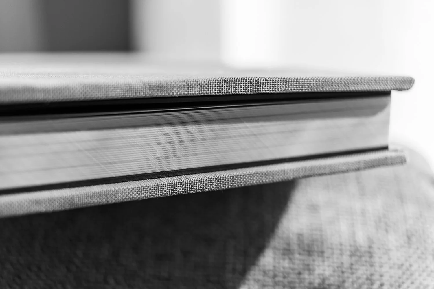 A close up view of the pages of a closed photo book, sitting in sunlight