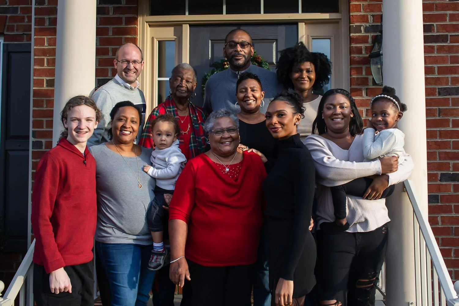 A multi-generation photo on the front porch of a home.