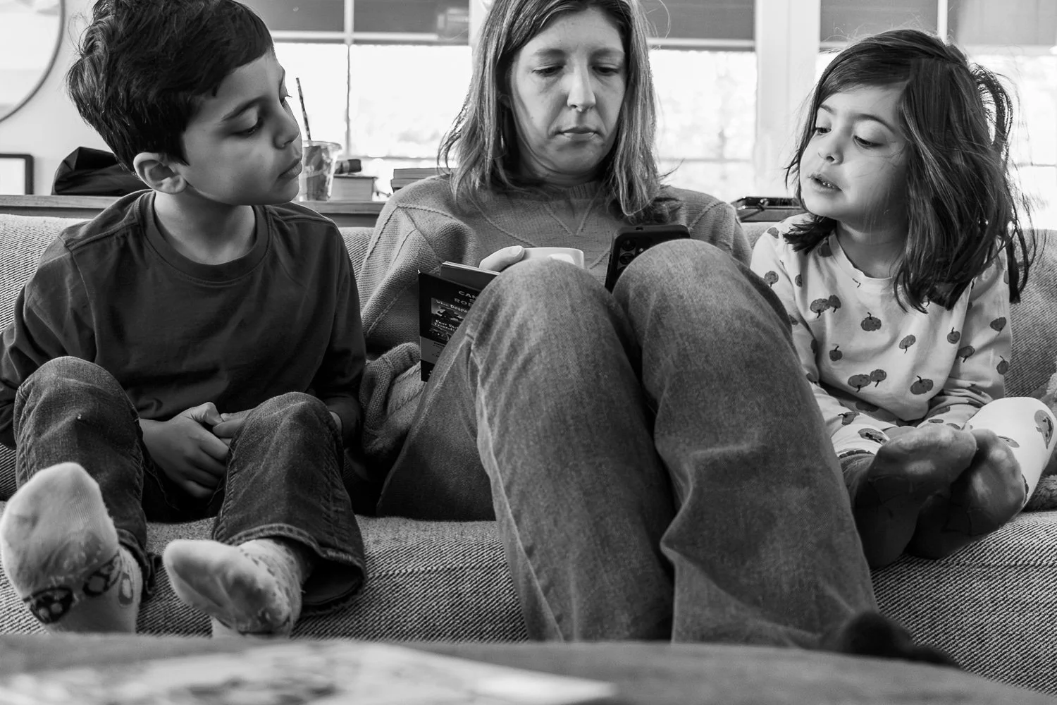 Allison Patel takes a self portrait with her kids as they also read a Dog Man book together on the couch.