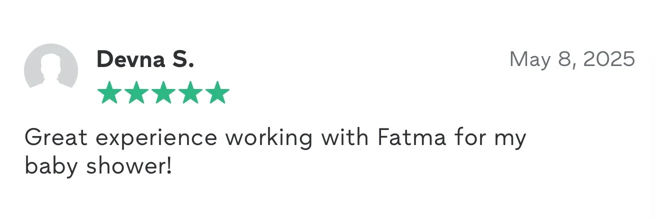 Scenic landscape of a large lake surrounded by rolling grassy hills and rugged mountains under cloudy sky.