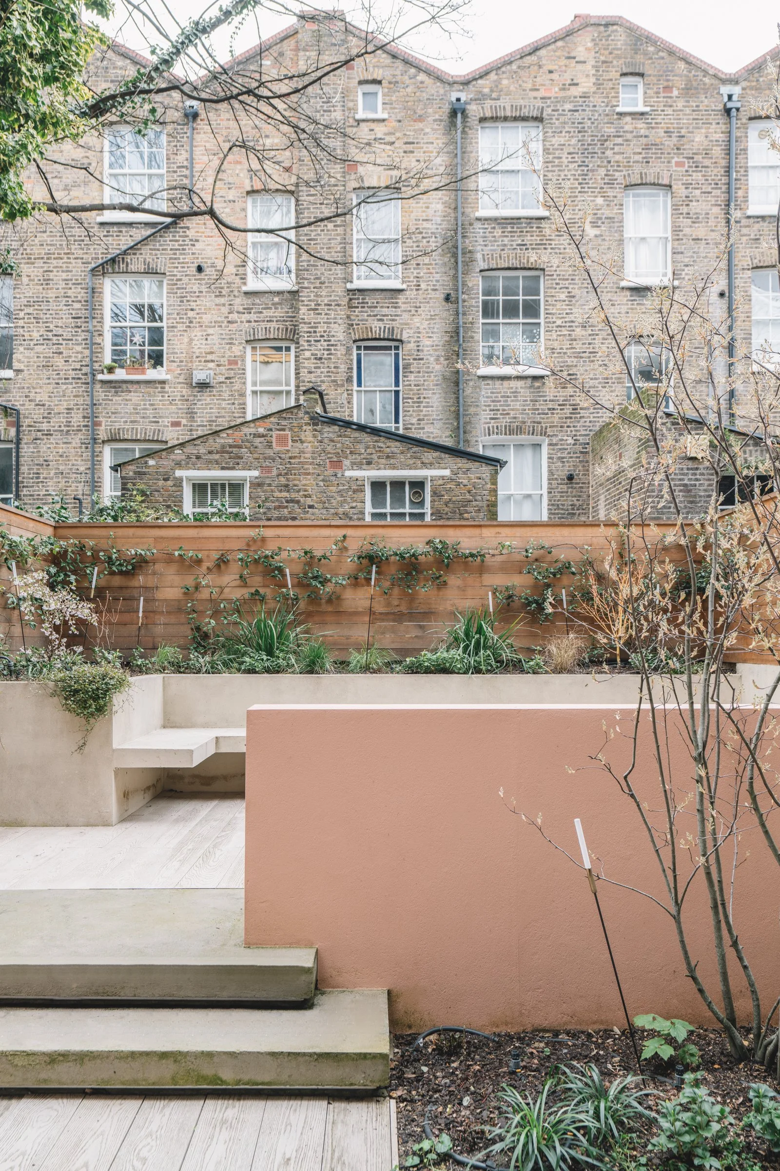 timber cladding, integrated seating and generous planting in a garden designed alongside the architecture of the house