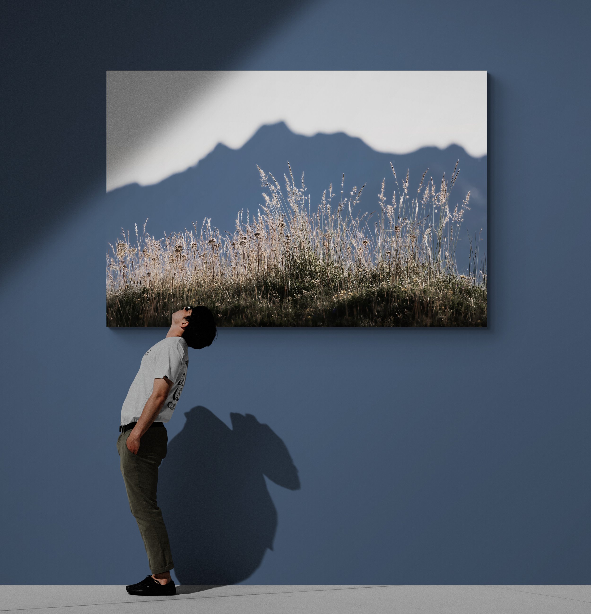 Young_man_standing_next_to_bare_wall.jpg