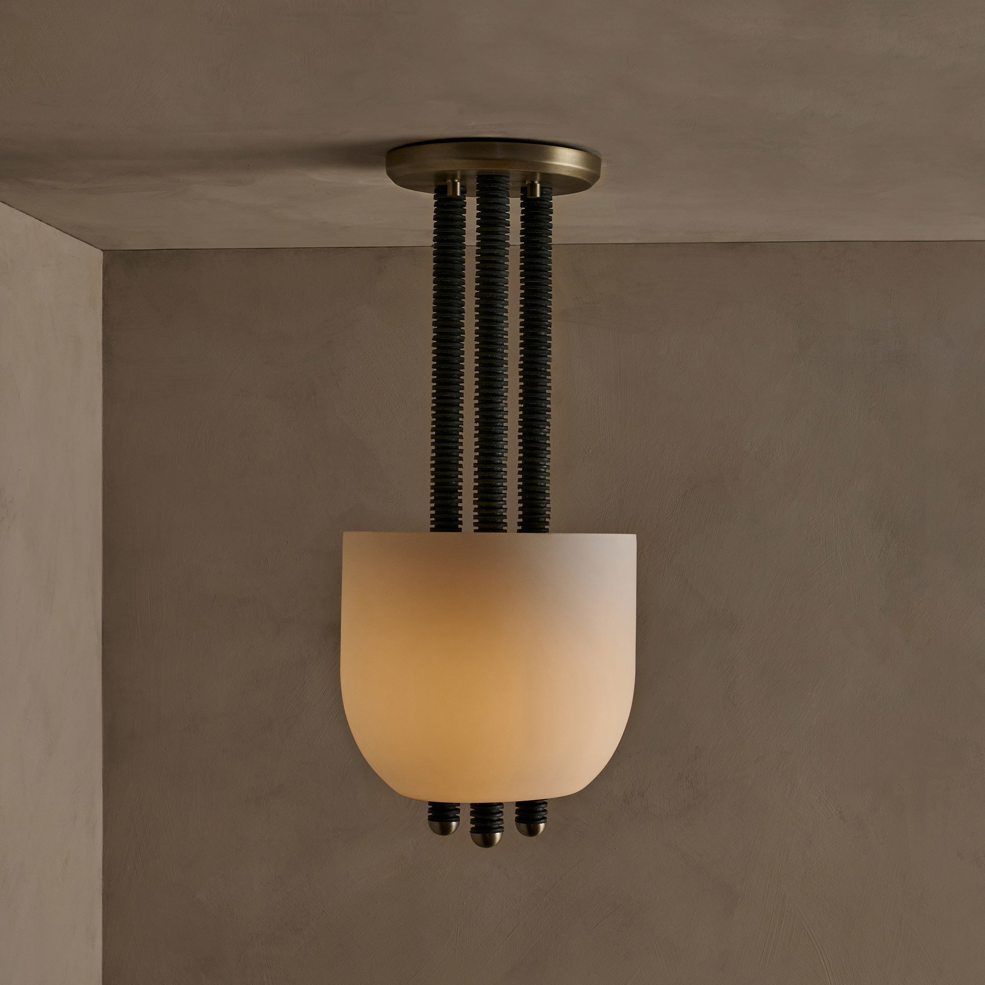 The Folton fixture showcases stacked leather hide disks, celebrating natural imperfections. A frosted glass shade illuminates the leather's edge while supports create a seamless union of components.